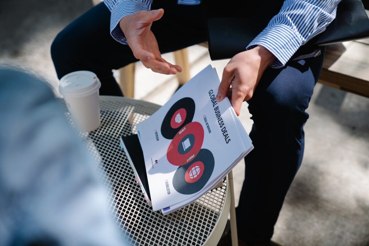 A businessman discusses global business deals with visual aids during an outdoor meeting.
